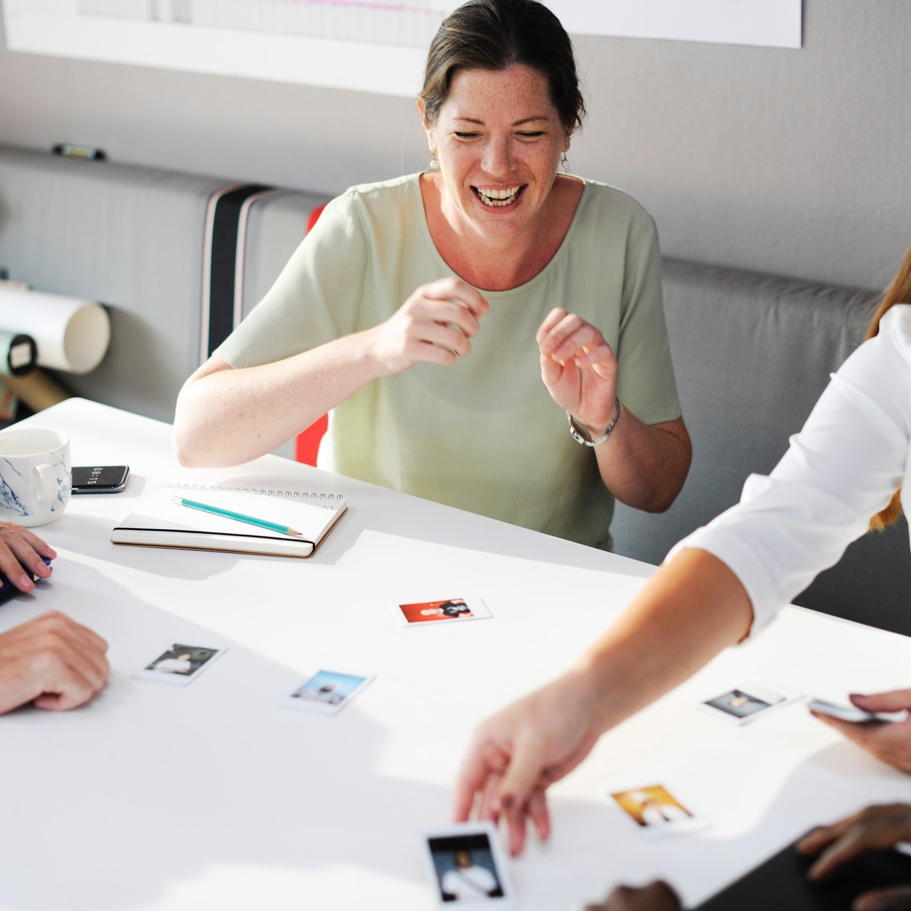 A group of people are sitting around a table with pictures on it and one of the pictures has the letter e on it