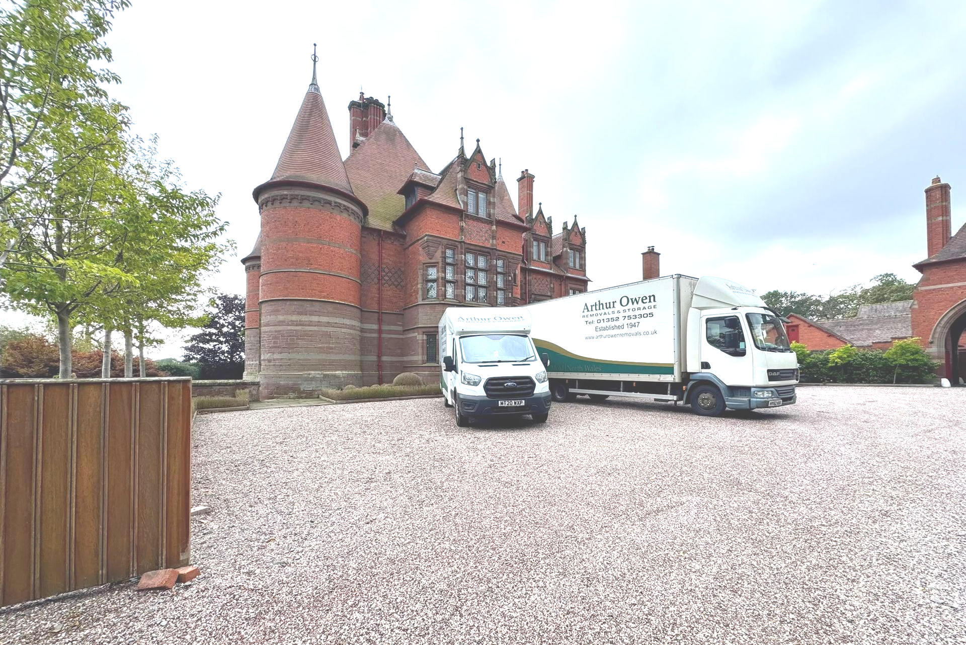 Arthur Owen Removals & Storage truck and van parked on gravel in front of the historic Eccleston Pad