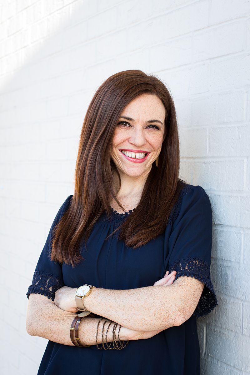 woman_leaning_up_against_wall_smiling_redhair_freckles_outdoor_sunset_headshot_houston_spring_thewoodlands_conroe_kingwood