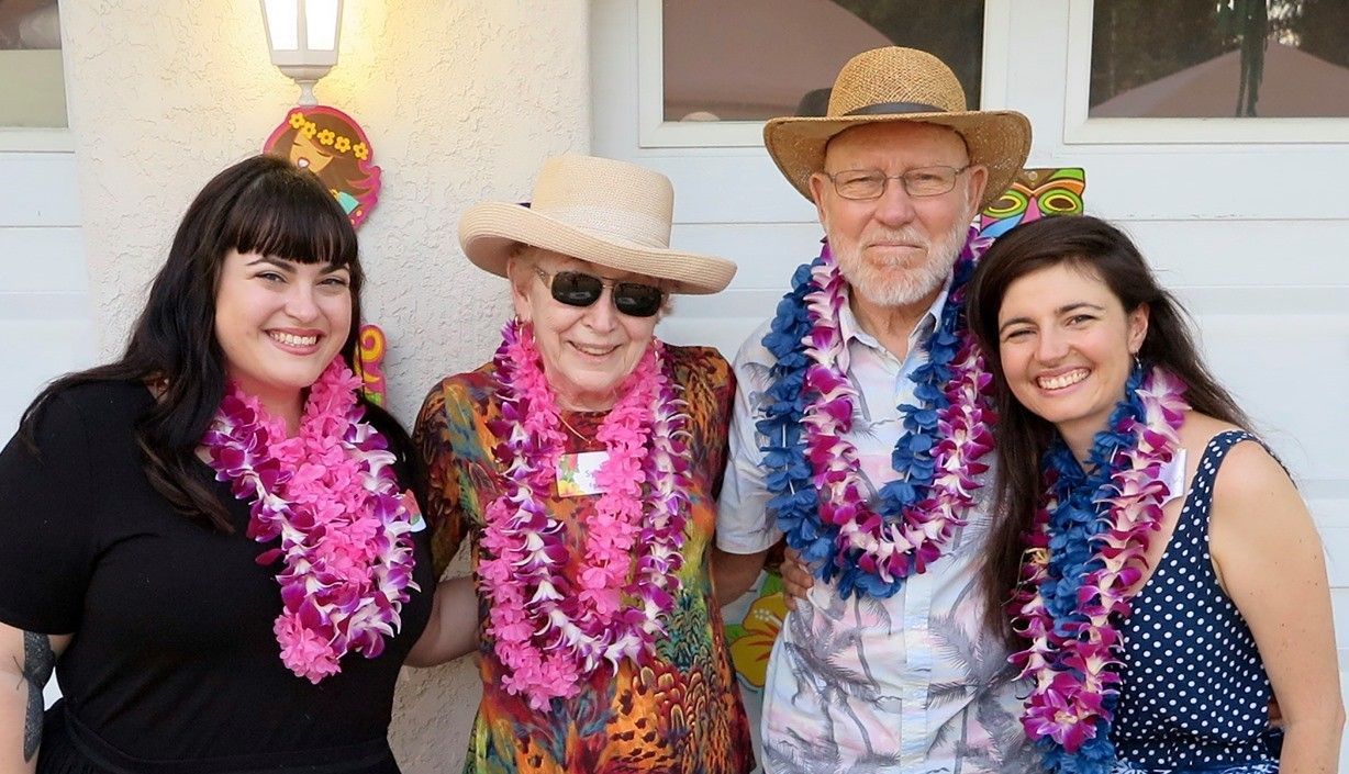 A group of people wearing lei are posing for a picture.