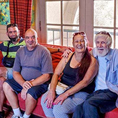 A group of people are sitting on a couch posing for a picture.