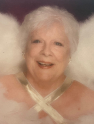 A woman is wearing angel wings and smiling for the camera.