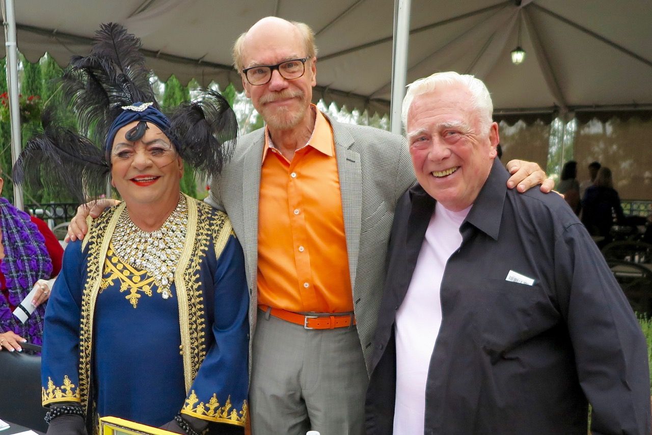 Three people posing for a picture in front of a tent