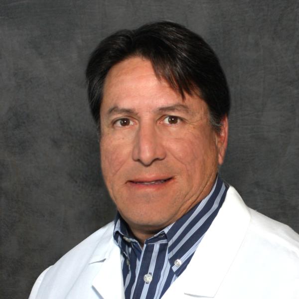 A man wearing a white lab coat and a blue and white striped shirt