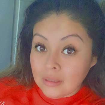 A close up of a woman 's face wearing a red shirt.