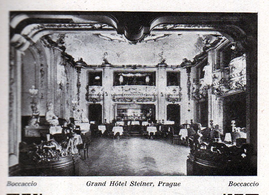 Vintage black-and-white photo of an ornate hotel lobby with chandeliers, arches, and seating areas