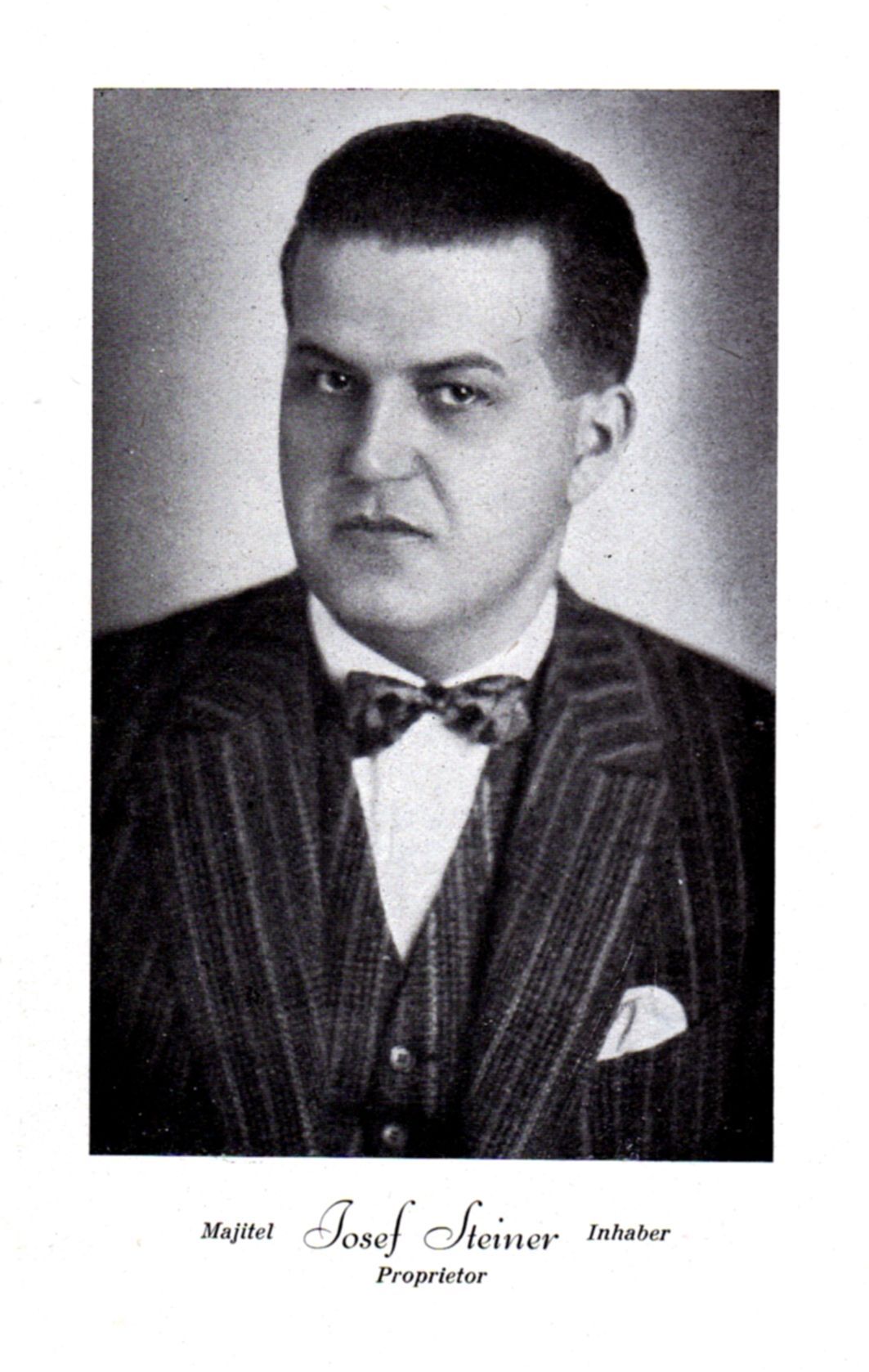 Black-and-white studio portrait of a man in a pinstripe suit and bow tie, looking at the camera.