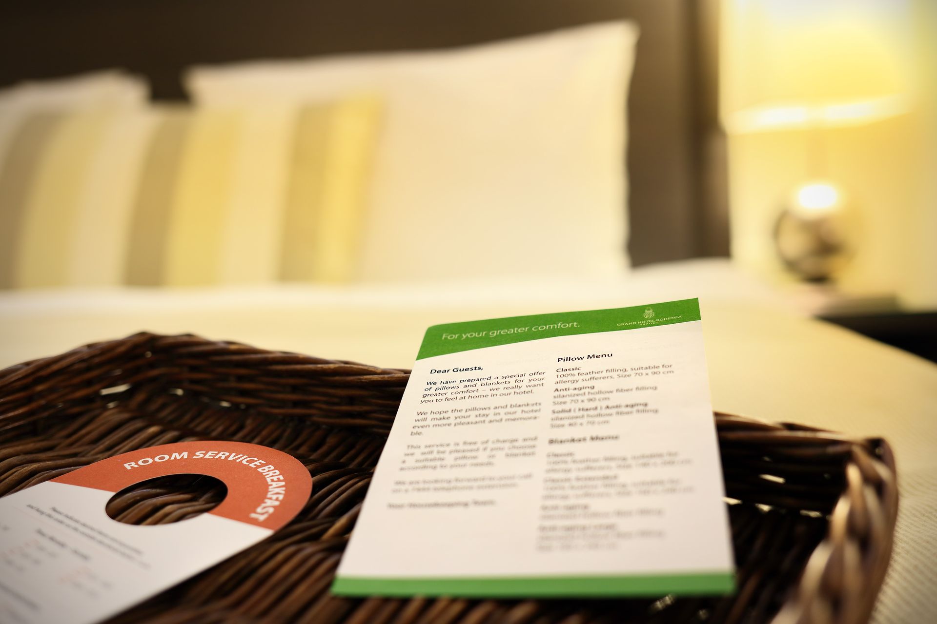 Brochure and menu on a woven tray in a softly lit bedroom