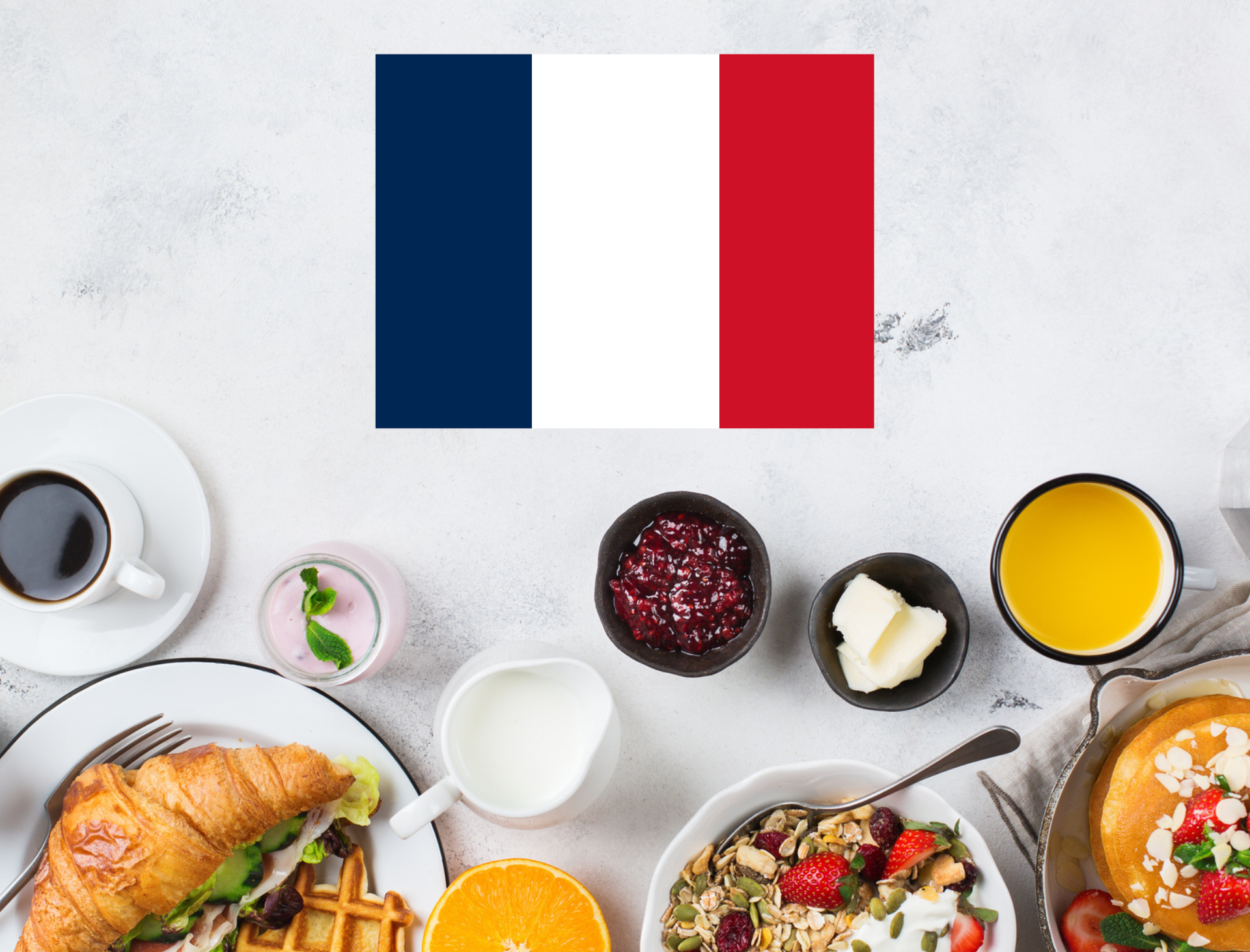 French flag above a table of breakfast foods, coffee, juice, pastries, and bowls of fruit and yogurt