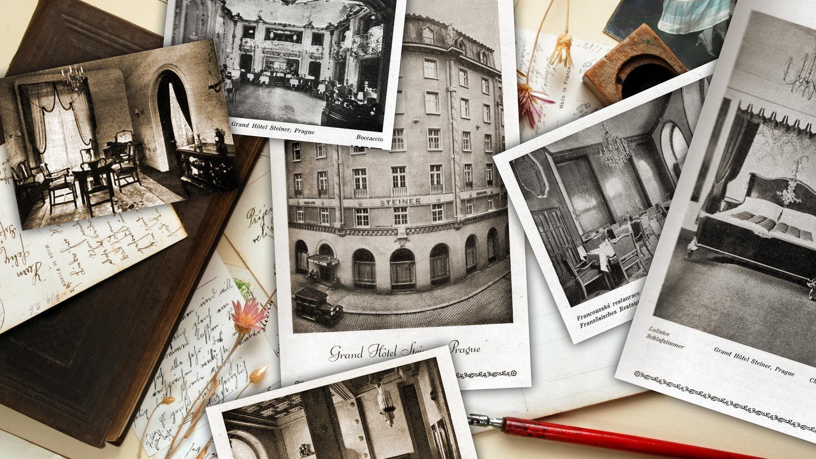 Scattered vintage black-and-white travel photos and postcards on a desk, with a red pencil and map beneath.