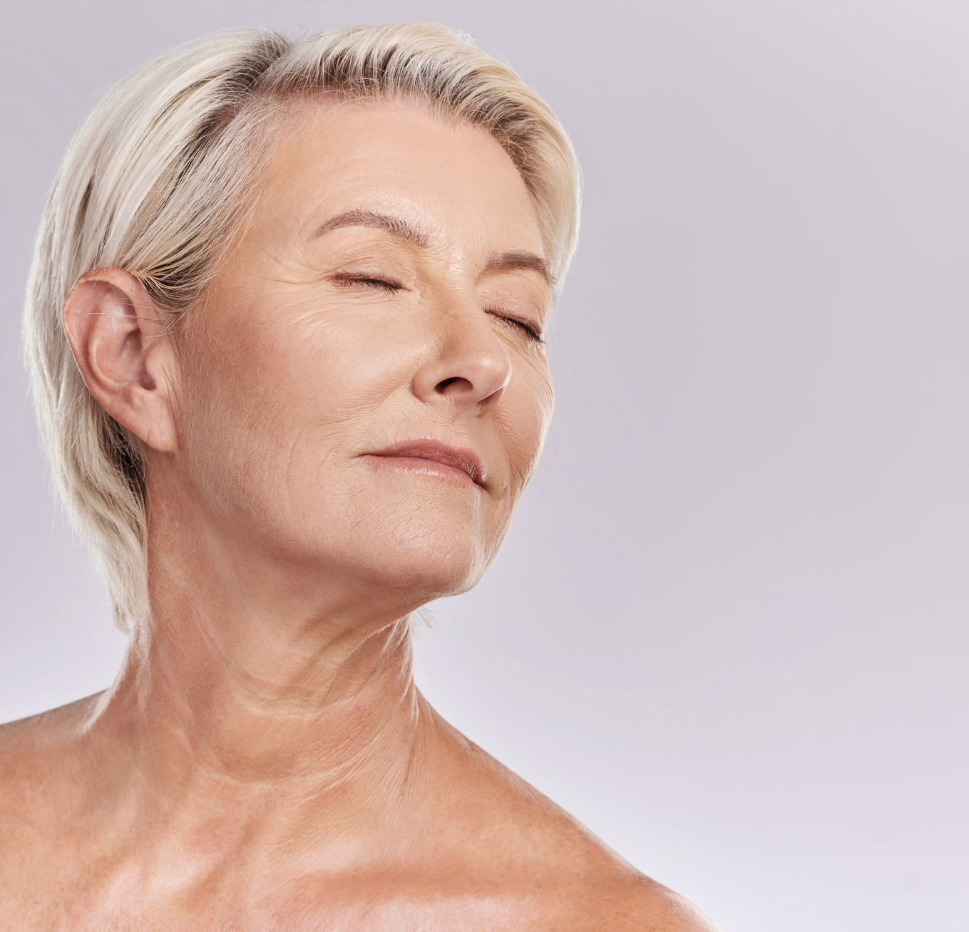A woman with closed eyes is turning her neck