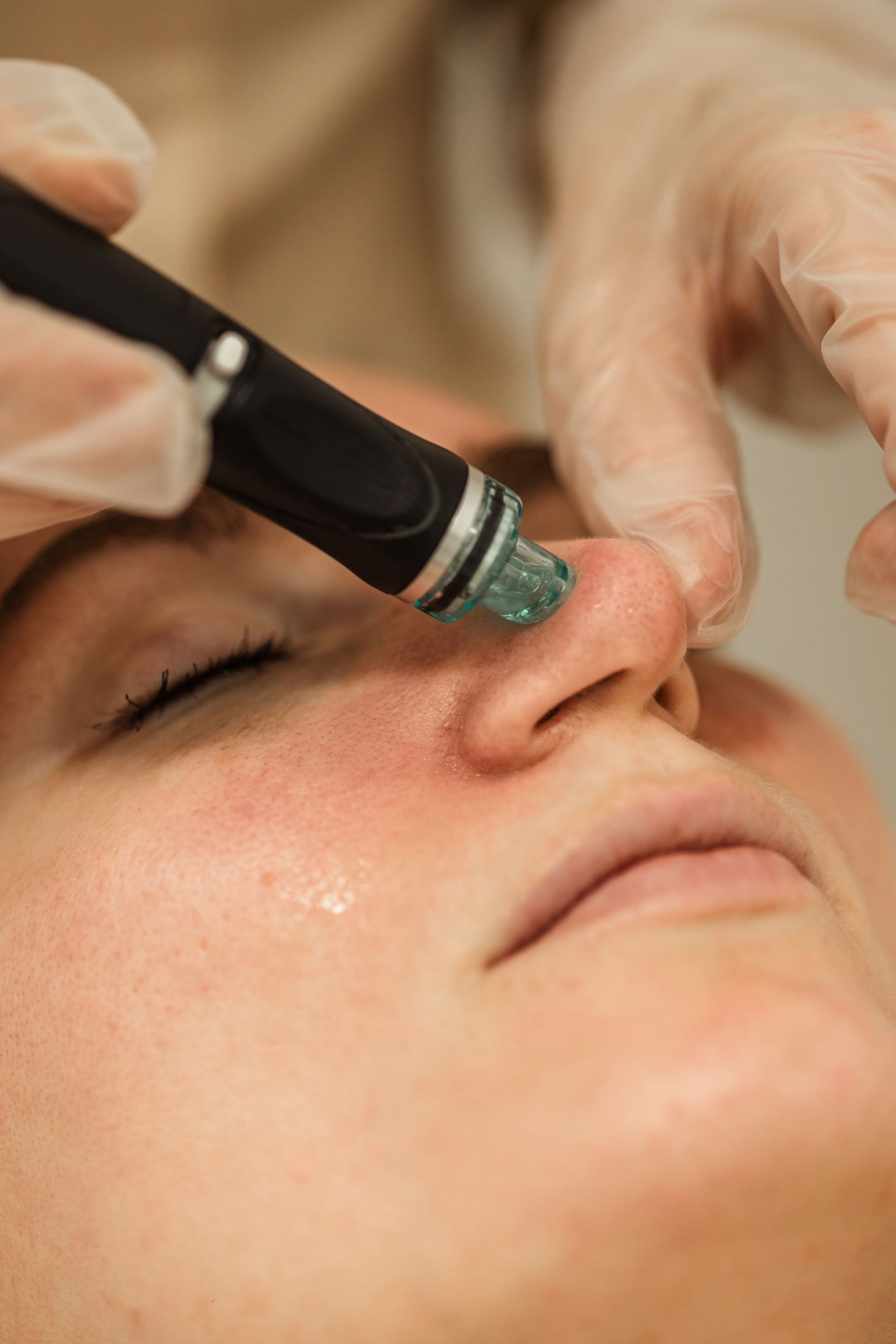A woman is getting a facial treatment with a machine on her face.