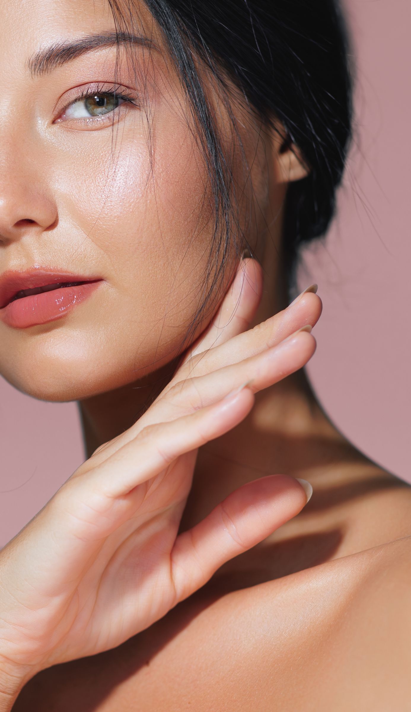 A close up of a woman 's face with her hand on it.