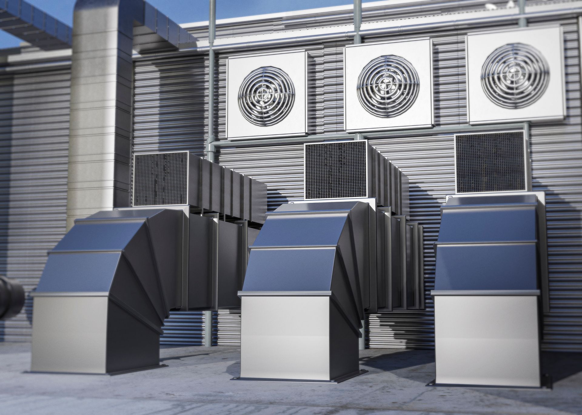 Industrial HVAC system with ducts and fan units mounted on a building exterior.