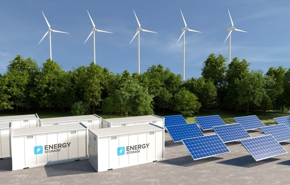 Wind turbines, solar panels, and battery storage units against a blue sky, symbolizing renewable energy.