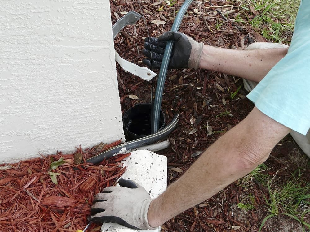 A Man Wearing Gloves Is Working On A Pipe — CQ Service Locating In Emerald, QLD