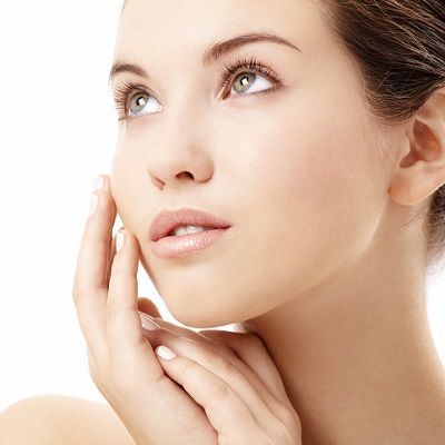 Woman with pale skin, hands near face, looking upward.