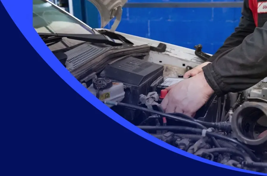 Technician working on engine of vehicle in Seattle, WA with blue background | Masters Auto & Tire