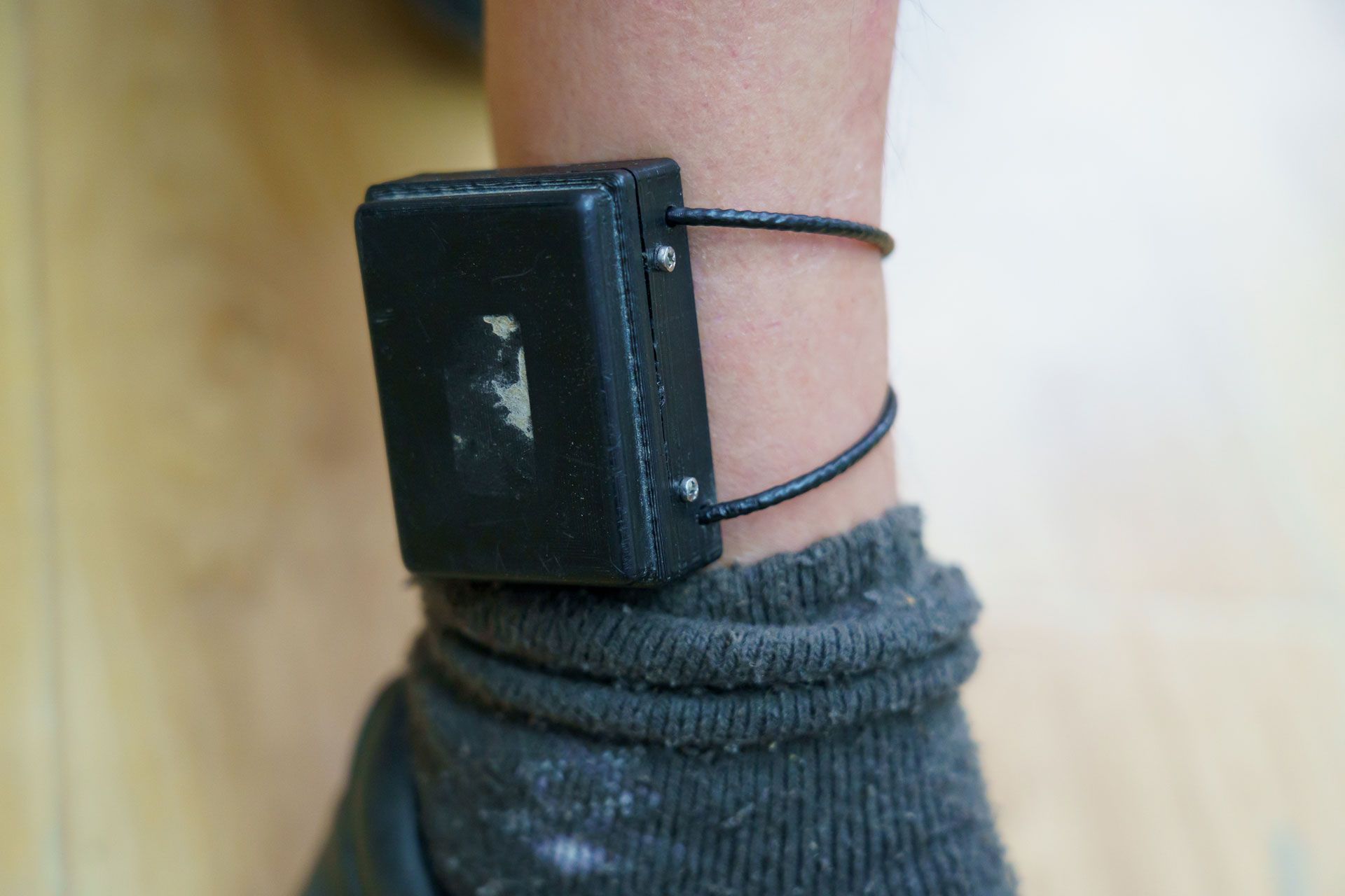 A person is wearing a GPS Monitoring on his ankle