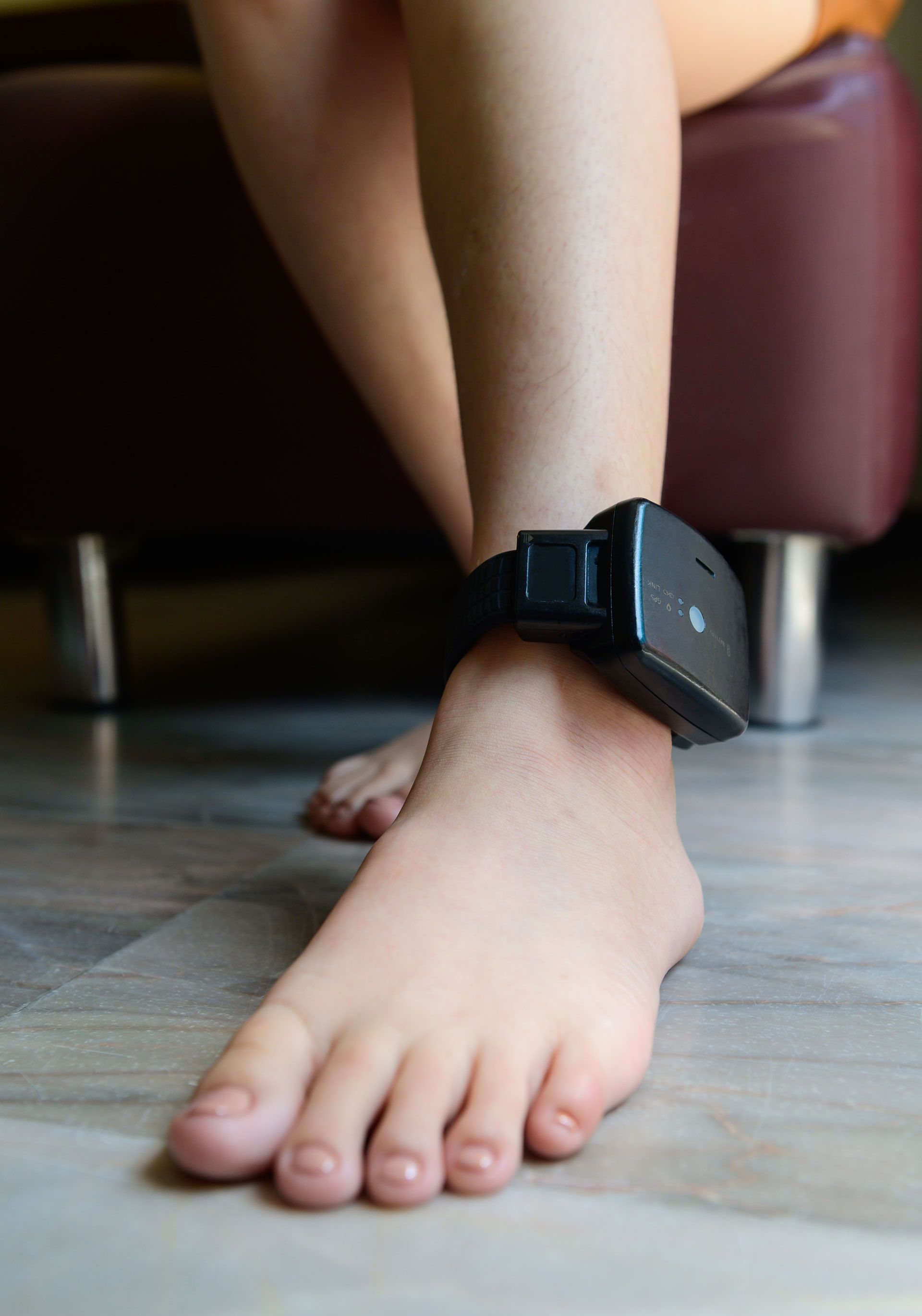 A person is wearing a GPS Monitoring on their ankle