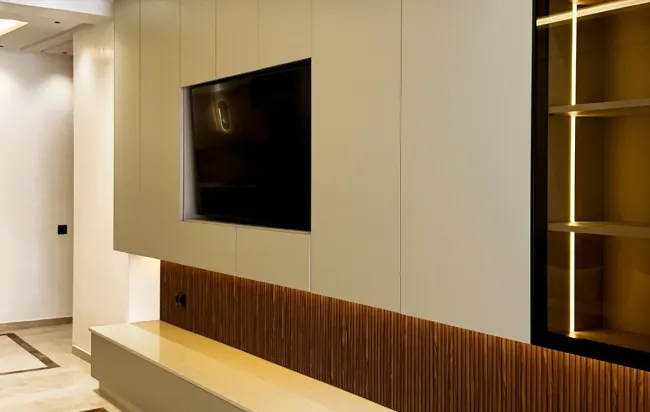 Meuble TV moderne avec télévision, rangements et vitrine avec éclairage intérieur.