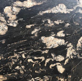Dark marble slab with white and tan veining and mottled mineral patterns