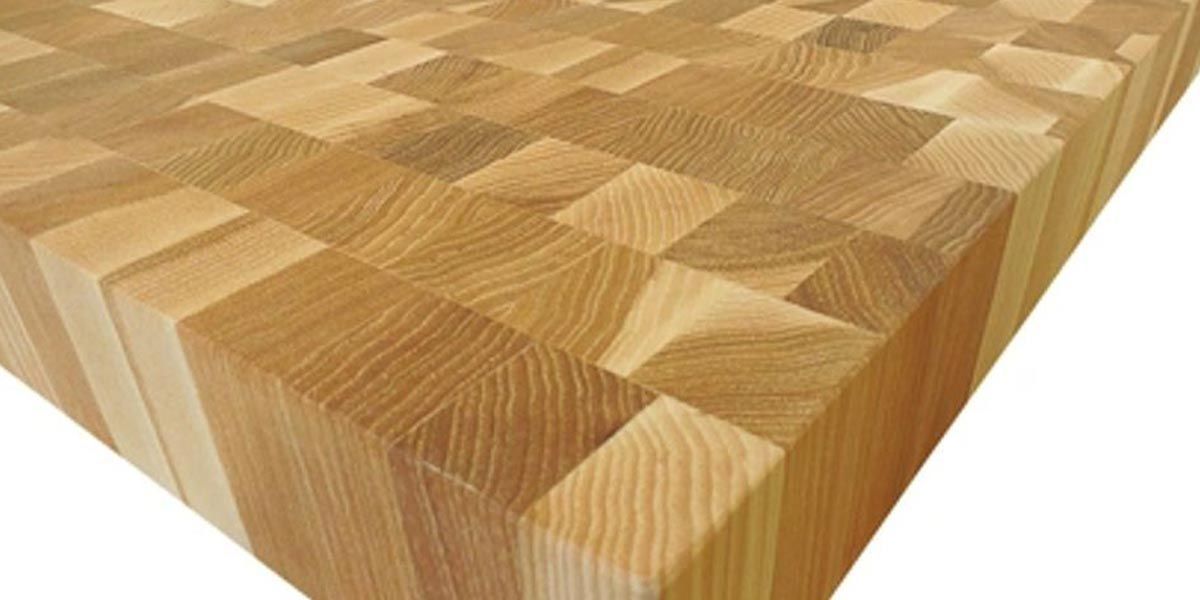 Wooden butcher block countertop with a geometric end-grain pattern in warm tan tones