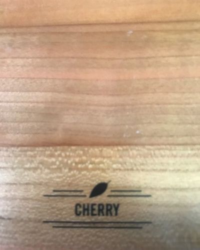 Close-up of a wooden surface with a small CHERRY logo printed near the bottom.