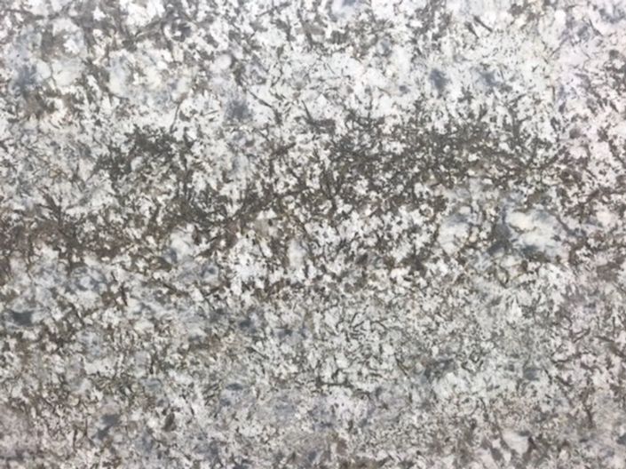 Close-up of a gray and white speckled stone or concrete surface with a rough texture