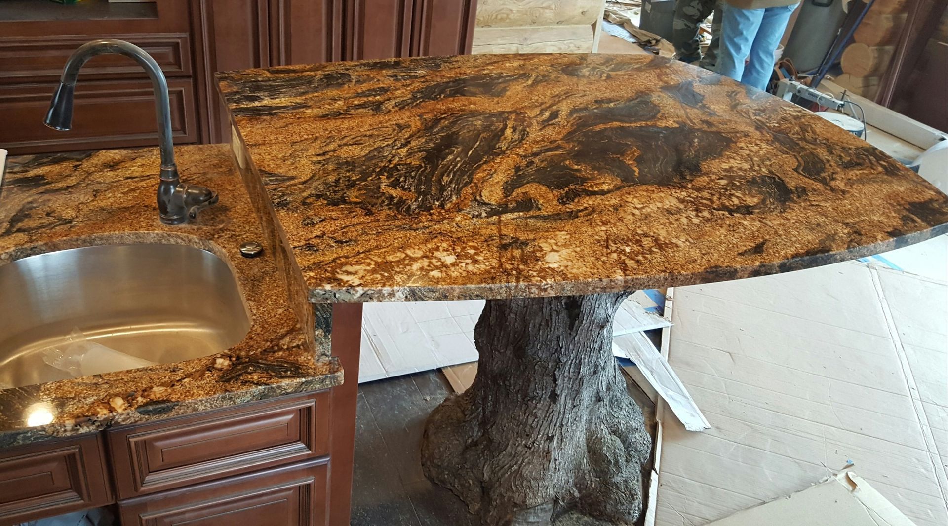 Kitchen counter with a sink and a large granite slab over a support stand under construction