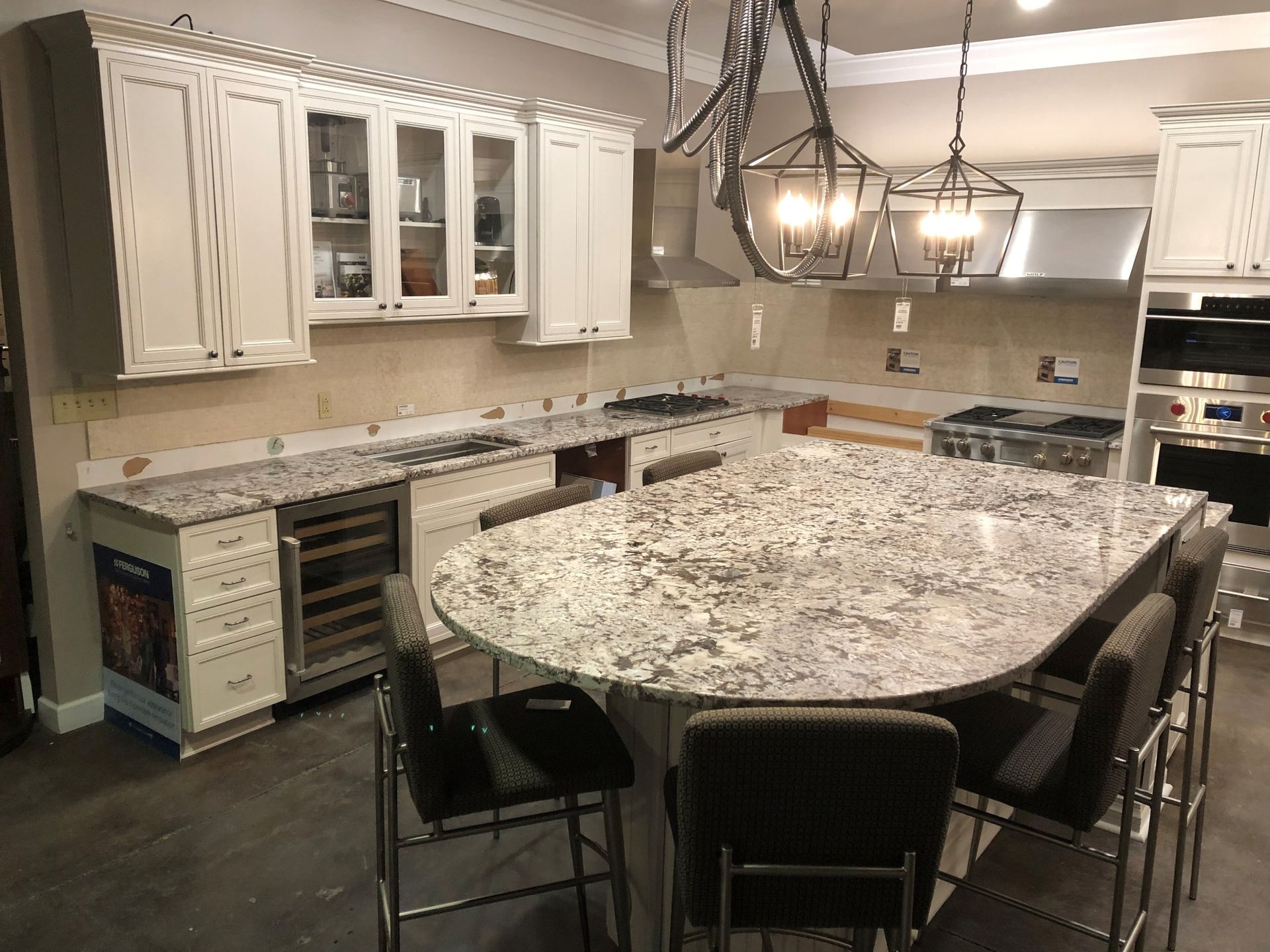 Modern kitchen with white cabinets, granite island, and hanging pendant lights