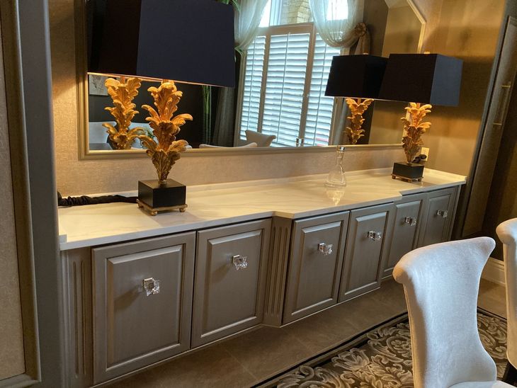 Modern bathroom vanity with mirror, lamps, and decorative vases in warm beige tones