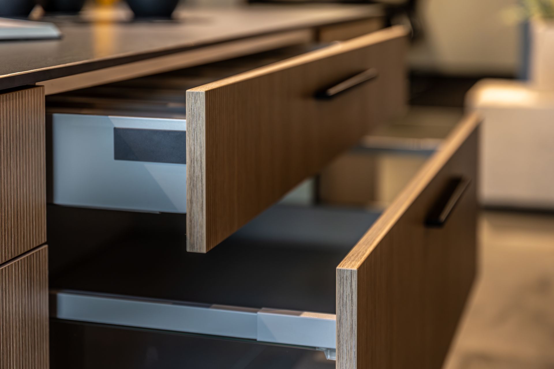 Open wooden office desk drawers partially extended in a modern workspace