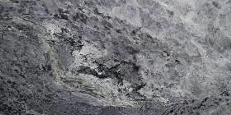 Gray rocky surface with a lighter, rough patch in the center