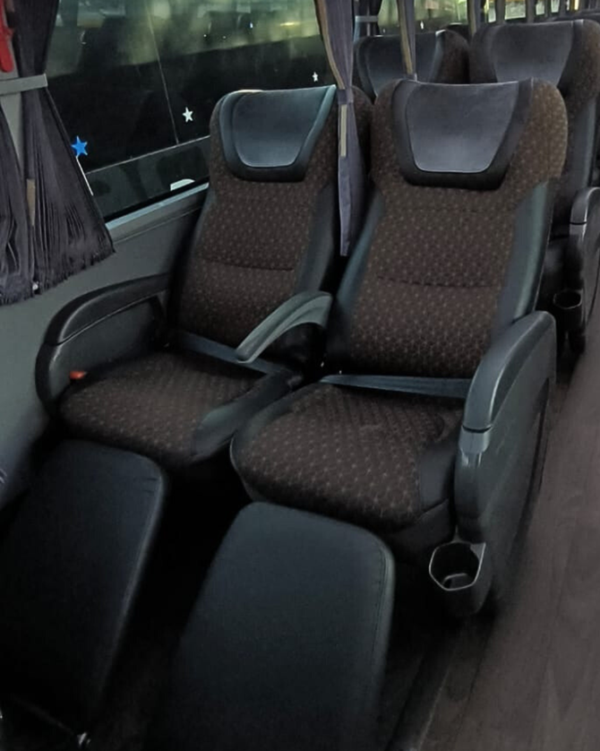 Imagem do interior do ônibus Leito Cama, com um cobertor no assento