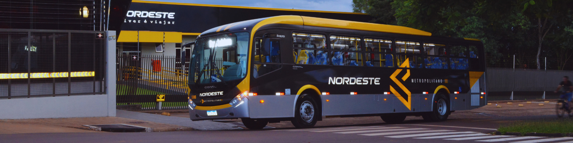 Um ônibus está passando pela rua em frente a um prédio.