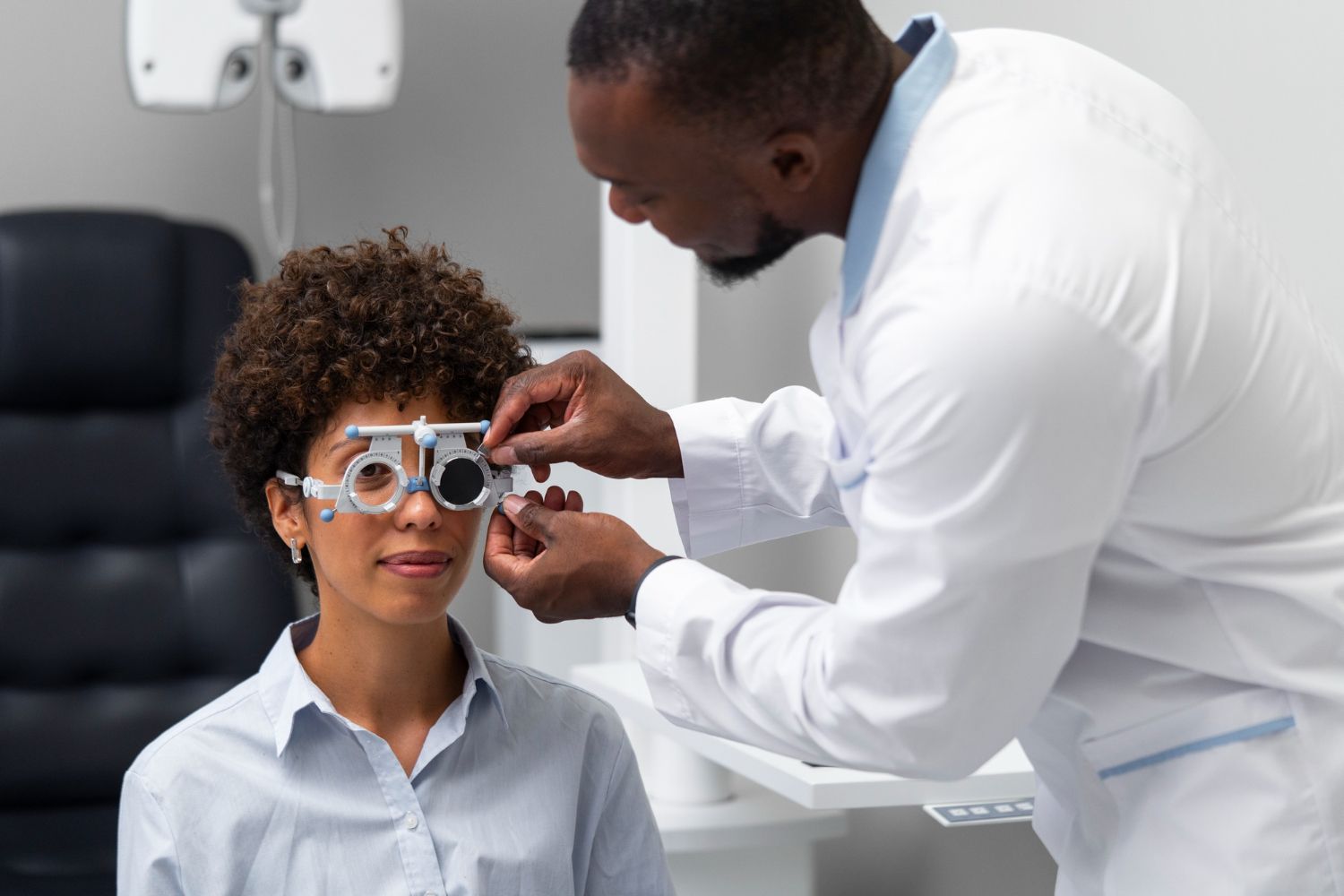 Optometrist adjusting lens frame on a patient during an eye exam.