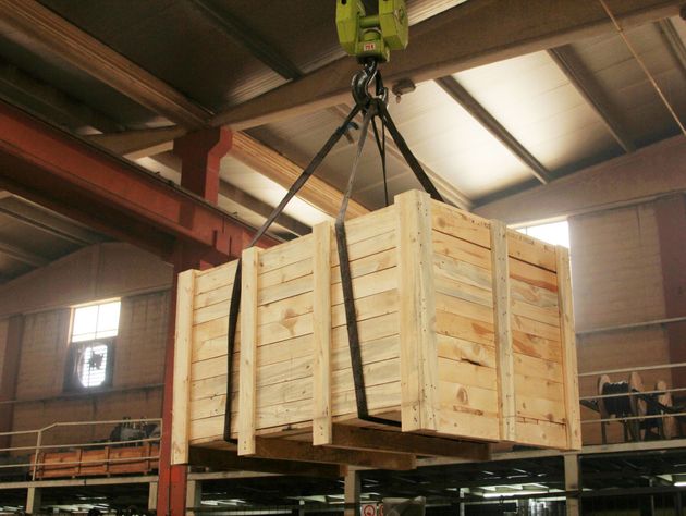 A large wooden box is being lifted by a crane. A large wooden box is being lifted by a crane.