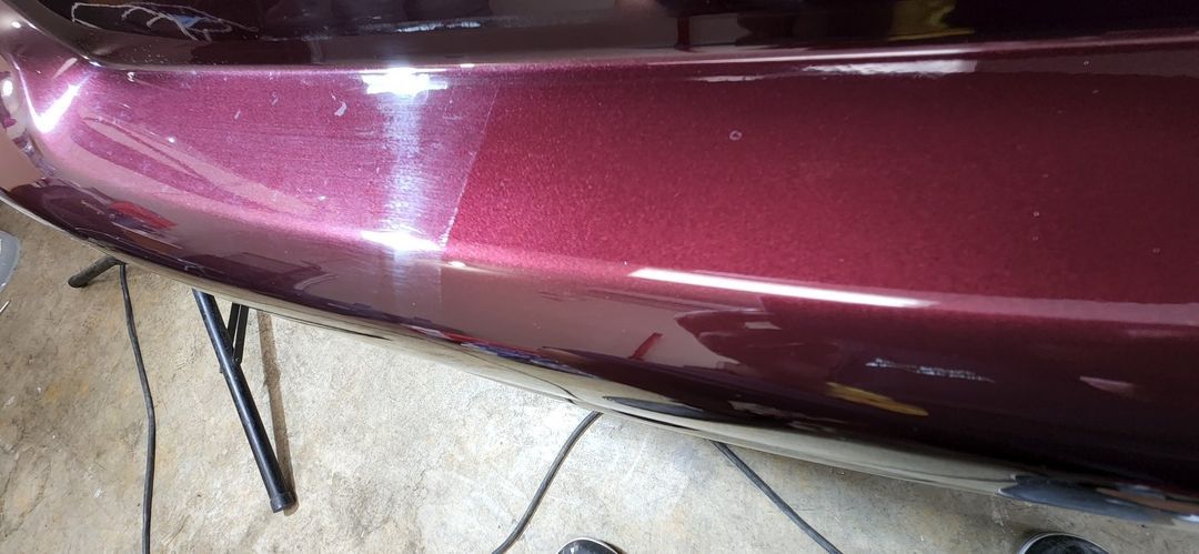 A close up of a red car bumper on a table.