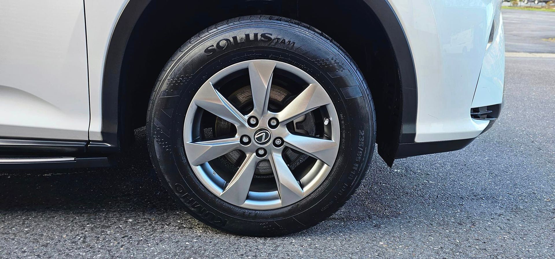 A close up of a car wheel on a road.