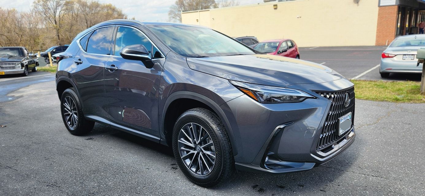 A gray lexus nx is parked in a parking lot.