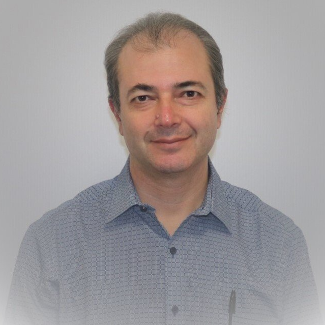 A man in a blue shirt is smiling for the camera