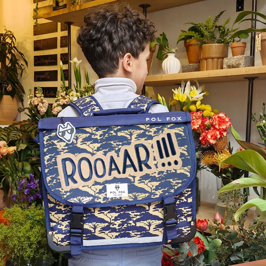 Cartable réversible Pol Fox porté par un enfant, motif lion