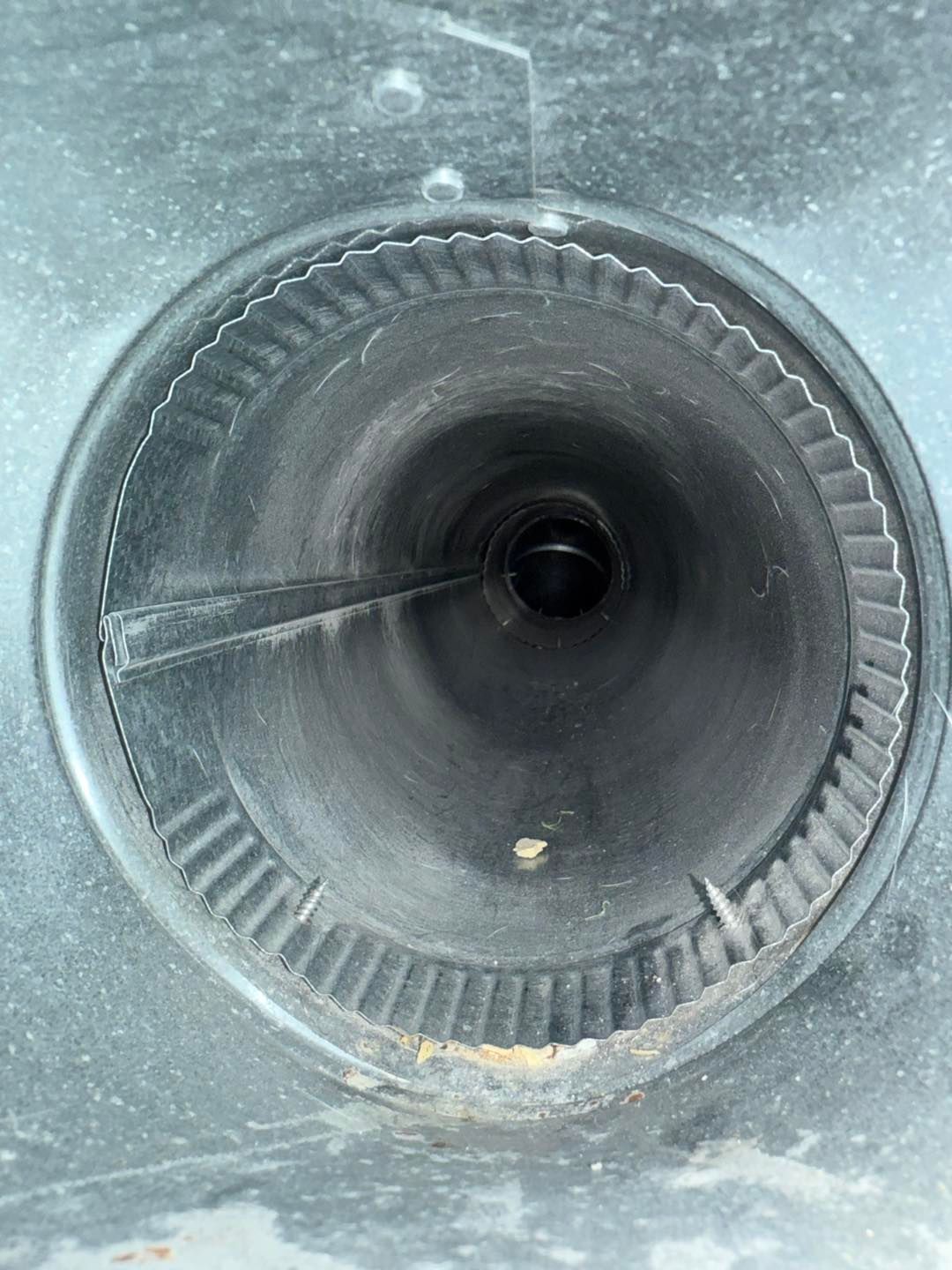 Close-up of a circular black speaker cone with a textured rim and dust around the edges