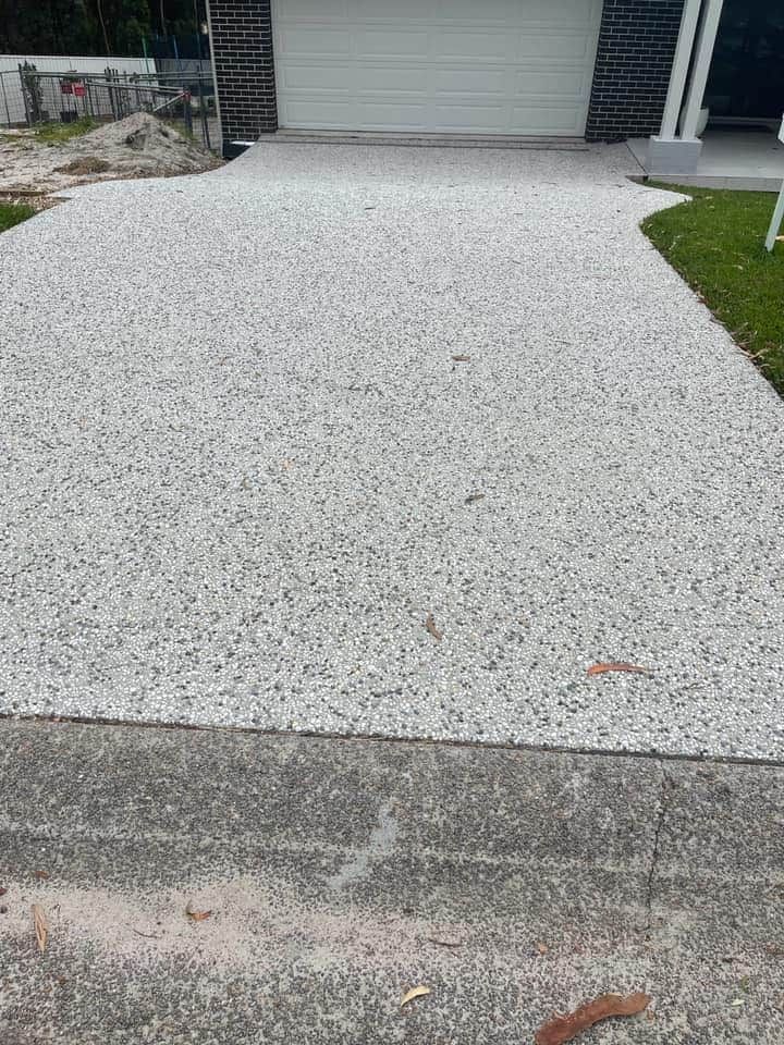 A Driveway With Gravel In Front Of A Garage Door — Tuncote Concrete Constructions in Anna Bay, NSW