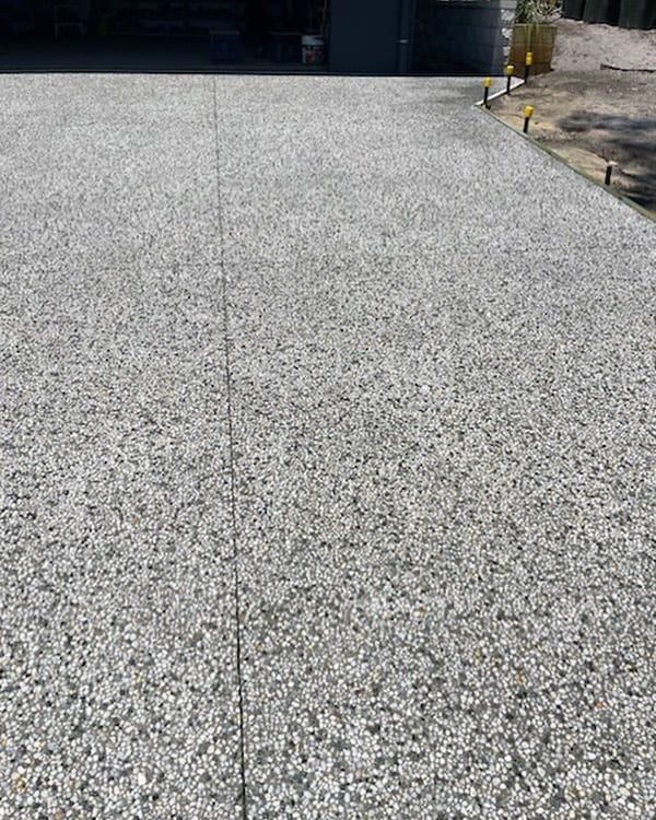 A Close Up Of A Concrete Driveway With A Yellow Fire Hydrant In The Background — Tuncote Concrete Constructions in Salamander Bay, NSW