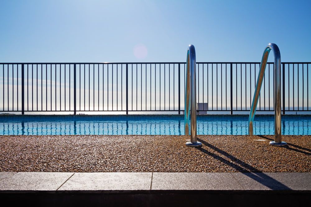 A Swimming Pool With A Fence Around It And Stairs Leading To It — Tuncote Concrete Constructions in Salamander Bay, NSW