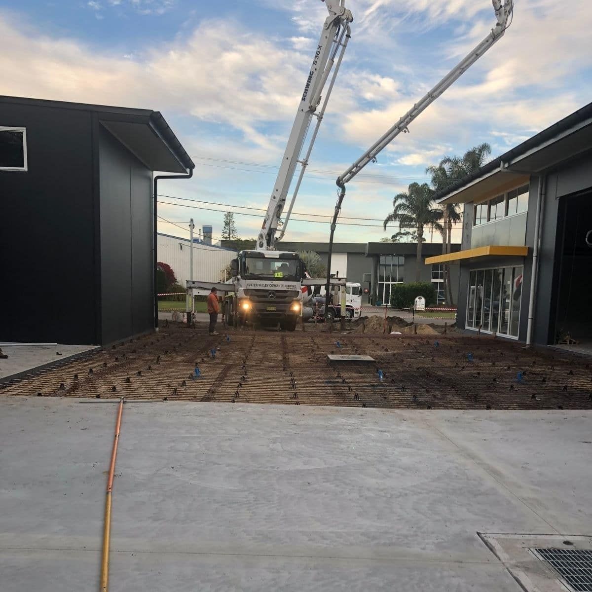 A Concrete Pump Is Being Used To Pour Concrete Into A Driveway — Tuncote Concrete Constructions in Anna Bay, NSW