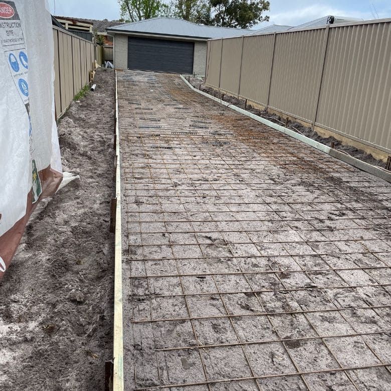 A Concrete Driveway Is Being Built In Front Of A House  — Tuncote Concrete Constructions in Nelson Bay, NSW
