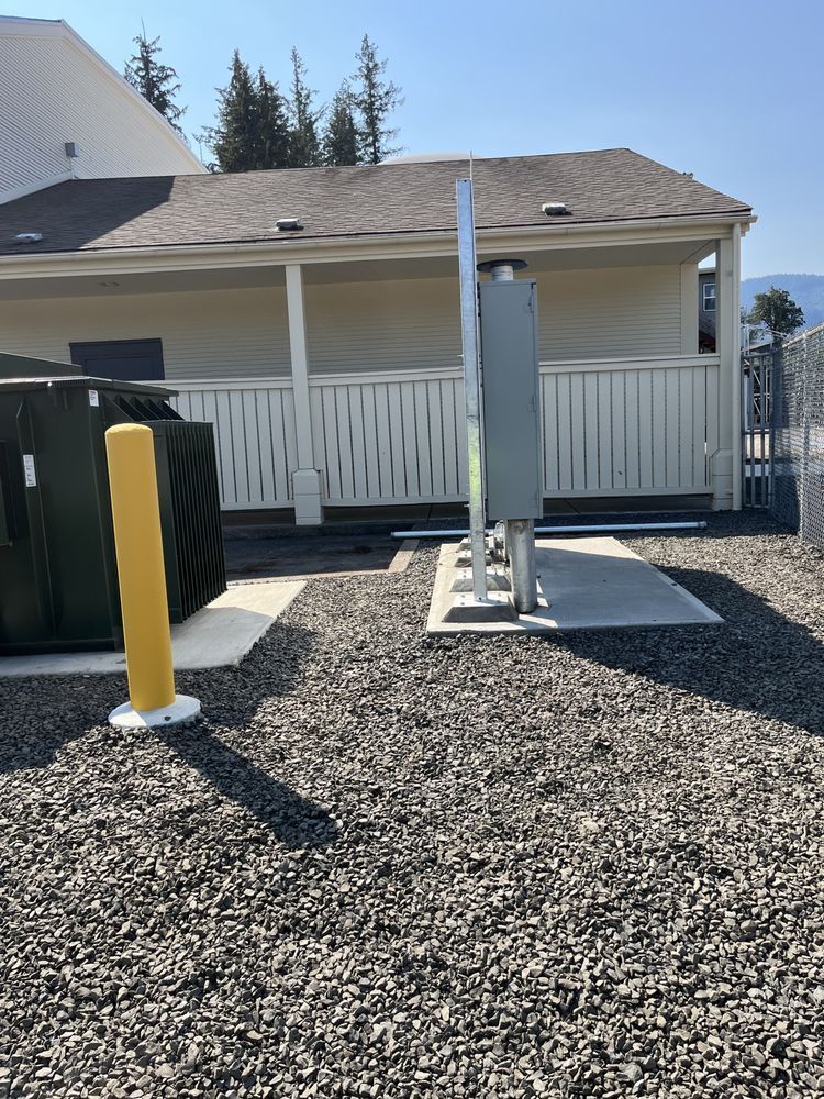 Backyard accessible platform lift beside a porch, with white railing and gravel ground